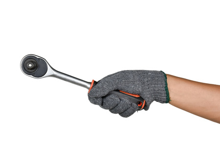 a hand with protection glove holding ratchet (socket) wrench