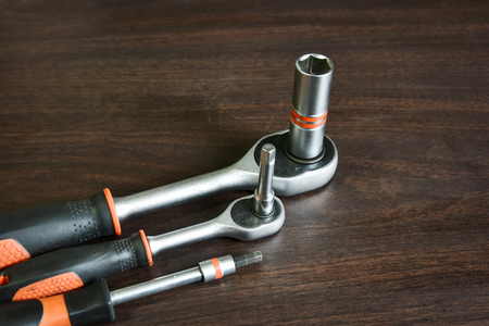 ratchet (socket) wrench lying on wooden background with copy space for text