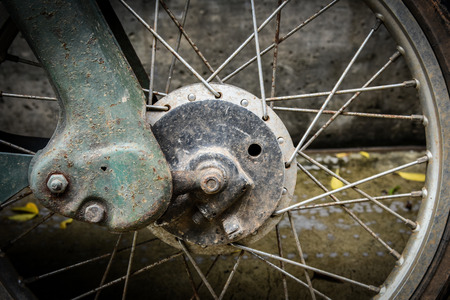 close up view of the front wheel and rusty exhaust of a vintage motorbike grungy styleの写真素材
