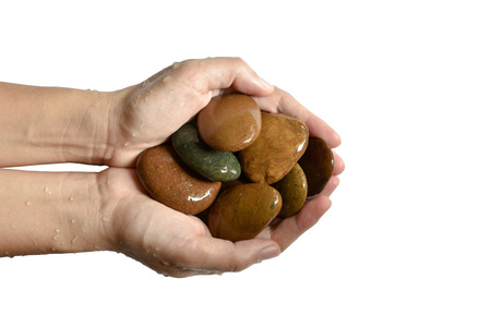 a wet hand holding a pebbles isolated on white backgroundの写真素材
