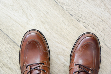 male brown leather shoes on wooden pattern tile floor