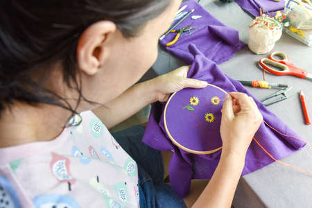 Asian woman sewing handcraft of sunflower pattern
