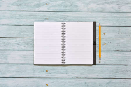 Still life, business office supplies or education concept, Top view image of open notebook and pencil with blank pages on old blue sky wooden background, ready for adding textの写真素材