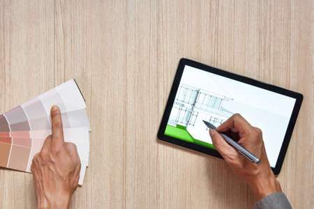 a top view of architect working desk with hand work color chart on equipment for drawings pens...