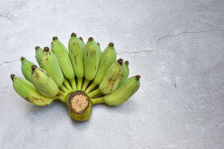 view of cultivated raw banana and banana blossom on the grungy cement floorの写真素材