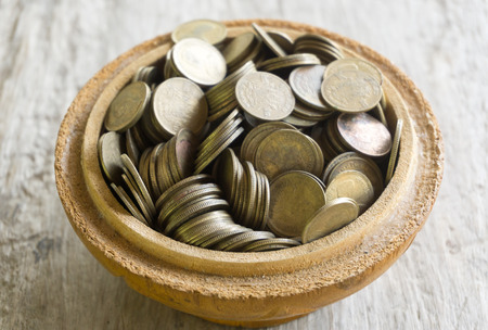 Old bowl filled with Thai baht coinの写真素材