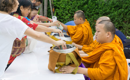 BANGKOK, THAILAND ,27 August 2016 : people put food offerings in a Buddhist monk's bowlのeditorial素材