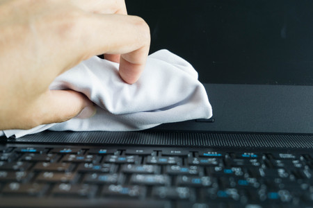 man hands cleaning laptop computer screen with clothの写真素材