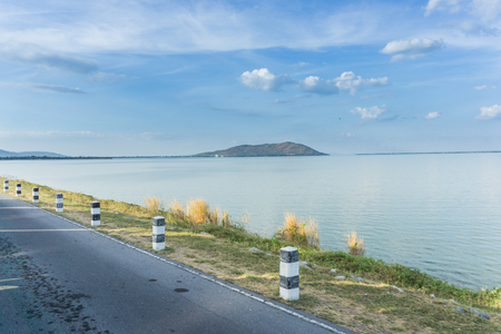 landscape with road and river under blue skyの写真素材