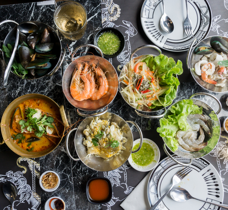 Thai seafood on table Include Tom Yum Goong, Papaya salad, Oyster Omelette, Raw shrimp.の写真素材