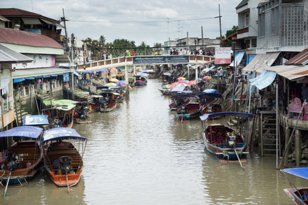 SAMUT SONGKHRAM, THAILAND - JULY 22, 2017 : AMPHAWA FLOATING MARKET, on weekends, the Amphawa Canal brims with boats loaded with drinks like O-Liang (Thai iced black coffee) and food such as fried sea mussels, noodles, and sweets. Bank-side wheelbarrows aのeditorial素材