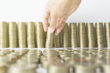 Woman's hand put money coins to stack of coins, Saving money concept.