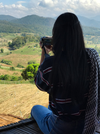 Female tourist is taking photo of beautiful Landscape.の写真素材