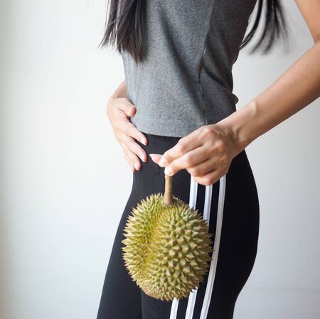Asian slim woman holding durian, king of fruit in Thailand, Health concept.の写真素材
