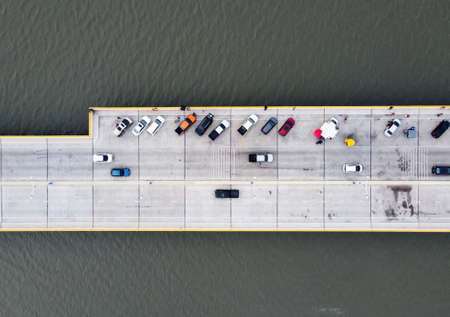 Top view of Many cars park on the bridge, and people take vacations such as taking pictures and sitting there.の写真素材