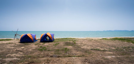 Beautiful sky and blue sea and 2 yellow-blue tents at the beaches in the morning.の写真素材