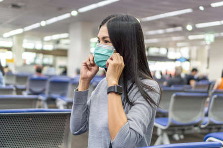 Traveling Asian women at the airport and wearing a mask to prevent the Coronavirus 19 Before boarding the plane.の写真素材