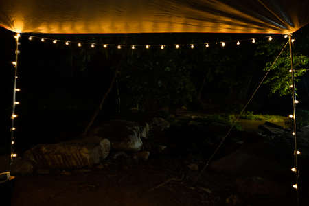 Beautiful rows of bulb lamps, light lamp decor glowing at outdoor camping.