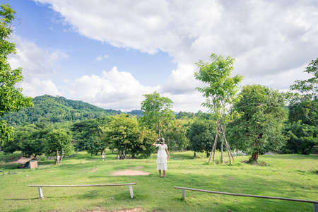 Women in white dresses in the garden, mountain and beautiful blue sky.の写真素材