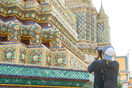Asian male tourist taking photo at Wat Pho, an important temple in Thailand's capital.の写真素材