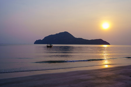 Local fishing boats on Sam Roi Yot beach in the morning, Beautiful golden reflections, big mountains, and a blue sky background.の写真素材