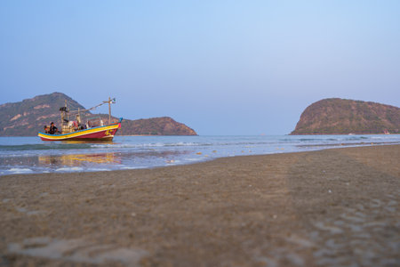 Local fishing boats on Sam Roi Yot beach in the morning, big mountains and blue sky background.