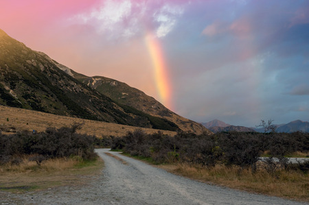 Rainbow over mountain near Lake Pearson / Moana Rua Wildlife Refuge located in Craigieburn Forest Park in Canterbury region, South Island of New Zealandの写真素材