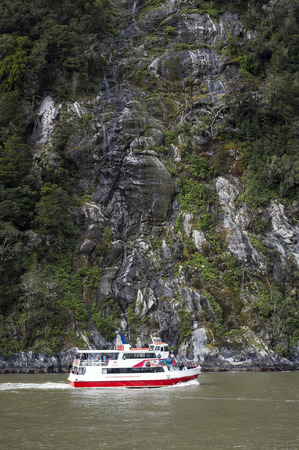Milford Sound, New Zealand - February 2016: Tourist boat cruises in the fjord of Milford Sound, South island of New Zealandのeditorial素材