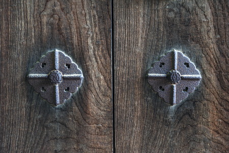 Texture background on Japanese ancient wooden door decorated with rusty metallic pinsの写真素材