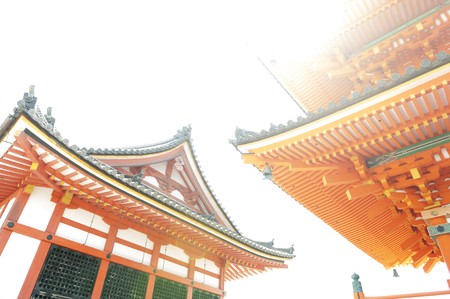 Low angle view of Japanese architecture buildings and roof details of pagoda against white sky at a Buddhist temple in Kyoto, Japanの写真素材