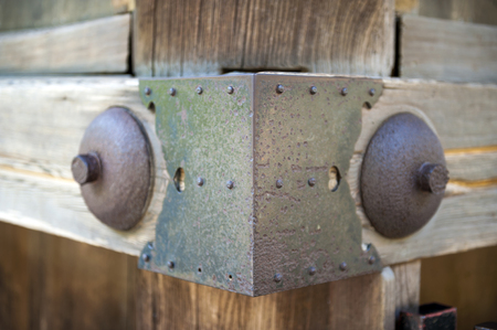 Traditional Japanese woodworking mitered butt joint supported by metallic pins and sheets at corner...