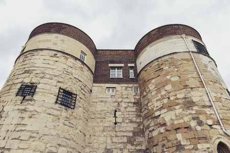 London, UK - April 2018: Old buildings and towers in the inner ward area of Royal Palace and Fortress of the Tower of London, a historic castle and popular tourist attraction located on the north bank of the River Thames in central London, Englandのeditorial素材