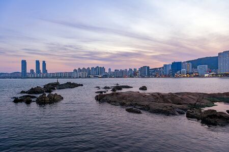 Busan, South Korea - April 2019: Cityscape with illuminated lights on buildings during sunset along Gwangalli Beach, a popular tourist destination in Busan, South Koreaのeditorial素材