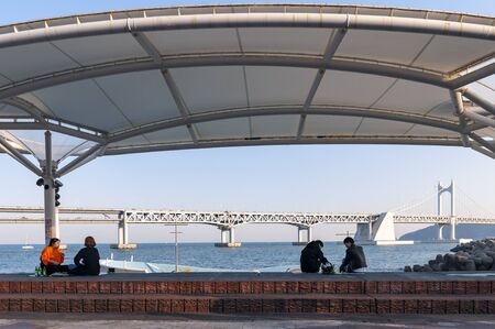 Busan, South Korea - April 2019: People relaxing and enjoying view of Busan Gwangandaegyo Bridge or...
