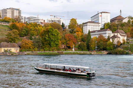 Schaffhausen, Switzerland - October 2019: Sightseeing boat taking tourists to the Rhine Falls,...
