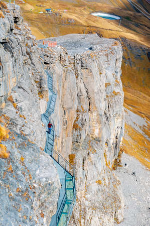 Lauterbrunnen, Switzerland - October 2019: Tourists walking on the Thrill Walk, the cliff pathway down into vertical walls of imposing rock massif located under Birg cableway station at Schilthorn mountain in the Alps, Switzerlandのeditorial素材