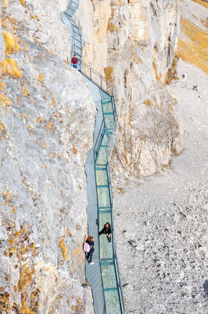 Lauterbrunnen, Switzerland - October 2019: Tourists walking on the Thrill Walk, the cliff pathway down into vertical walls of imposing rock massif located under Birg cableway station at Schilthorn mountain in the Alps, Switzerlandのeditorial素材