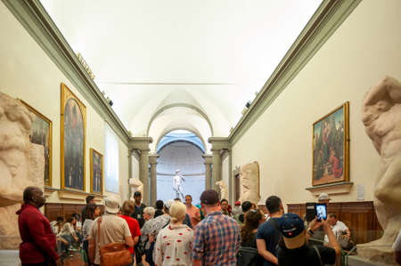 Florence, Italy - October 2019: A crowd of visitors gathering in the Galleria dell'Accademia di Firenze (Gallery of the Academy of Florence) to see the famous marble statue of David by Michelangeloのeditorial素材