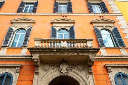 Low angle shot showing details of European classic building with beautiful Italian architectural style window panels located on street of Rome in Italyの写真素材