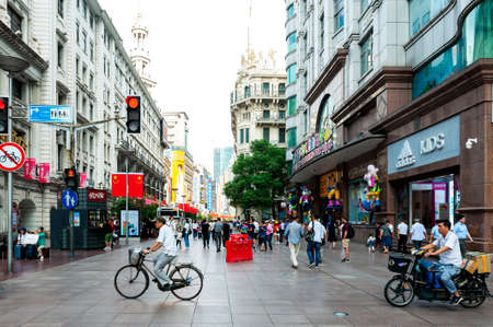 Shanghai, China - September 2019: People on walk street paralleled both sides by commercial buildings located on the eastern part of Nanjing Road, the busiest shopping street in downtown business centre of Shanghai city, Chinaのeditorial素材