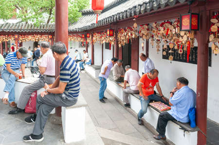 Shanghai, China - September 2019: Local people enjoying Chinese chess game at The Bell Tower in Qibao Ancient Town, a historic water township of Qibao in the Minhang District of Shanghai, Chinaのeditorial素材