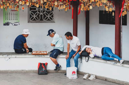 Shanghai, China - September 2019: Local people enjoying Chinese chess game at The Bell Tower in Qibao Ancient Town, a historic water township of Qibao in the Minhang District of Shanghai, Chinaのeditorial素材