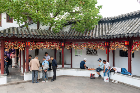 Shanghai, China - September 2019: Local people enjoying Chinese chess game at The Bell Tower in Qibao Ancient Town, a historic water township of Qibao in the Minhang District of Shanghai, Chinaのeditorial素材