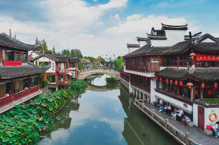 Shanghai, China - September 2019: Traditional Chinese teahouses and buildings along the riverbank of the Puhui River in Qibao Ancient Town, a historic water township of Qibao in the Minhang District of Shanghai, Chinaのeditorial素材