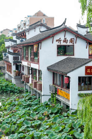 Shanghai, China - September 2019: Traditional Chinese teahouses and buildings along the riverbank of the Puhui River in Qibao Ancient Town, a historic water township of Qibao in the Minhang District of Shanghai, Chinaのeditorial素材