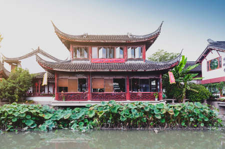 Shanghai, China - September 2019: Traditional Chinese teahouses and buildings along the riverbank of the Puhui River in Qibao Ancient Town, a historic water township of Qibao in the Minhang District of Shanghai, Chinaのeditorial素材
