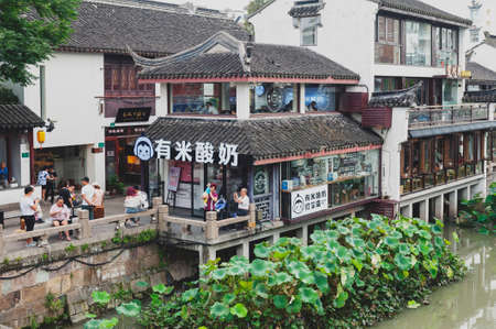 Shanghai, China - September 2019: Traditional Chinese teahouses and buildings along the riverbank of the Puhui River in Qibao Ancient Town, a historic water township of Qibao in the Minhang District of Shanghai, Chinaのeditorial素材