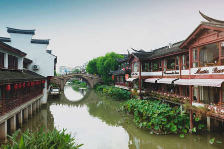 Shanghai, China - September 2019: Traditional Chinese teahouses and buildings along the riverbank of the Puhui River in Qibao Ancient Town, a historic water township of Qibao in the Minhang District of Shanghai, Chinaのeditorial素材