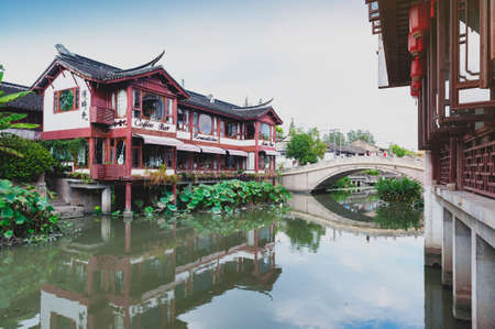 Shanghai, China - September 2019: Traditional Chinese teahouses and buildings along the riverbank of the Puhui River in Qibao Ancient Town, a historic water township of Qibao in the Minhang District of Shanghai, Chinaのeditorial素材