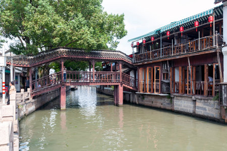Shanghai, China - September 2019: Ancient wooden roofed bridge built in Chinese architecture style lying over a canal in Zhujiajiao Ancient Water Town, a historic village located in the Qingpu District of Shanghai, Chinaのeditorial素材